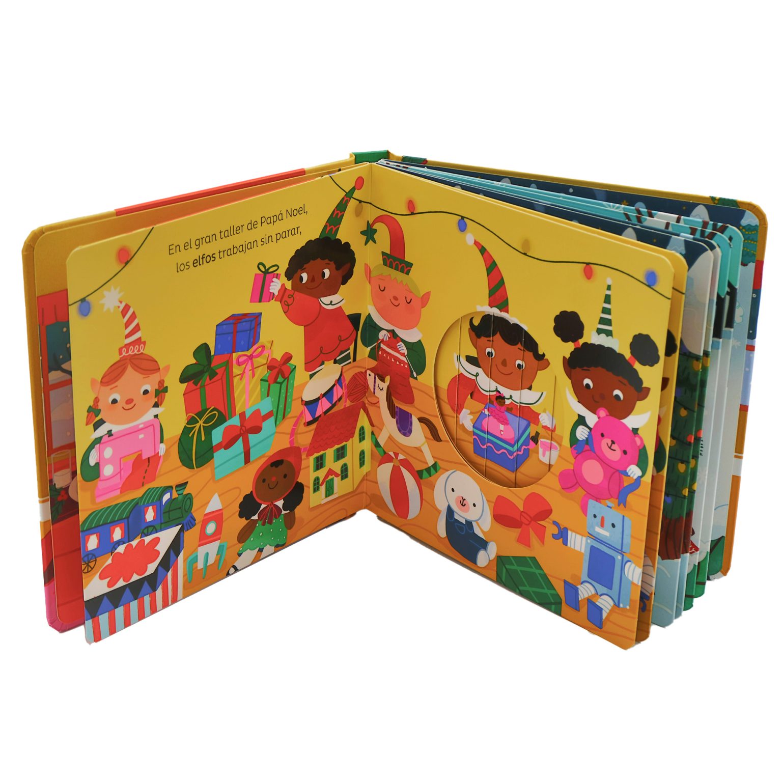 Niño pequeño sentado hojeando el libro “¡Feliz Navidad!”, sorprendido por las figuras pop-up que se levantan al abrir la página.