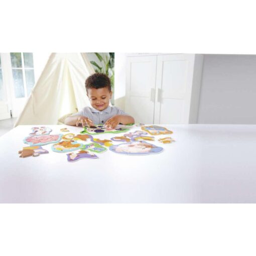 Niño montando puzzle de vaca del set Amigos de la Granja de Hape.