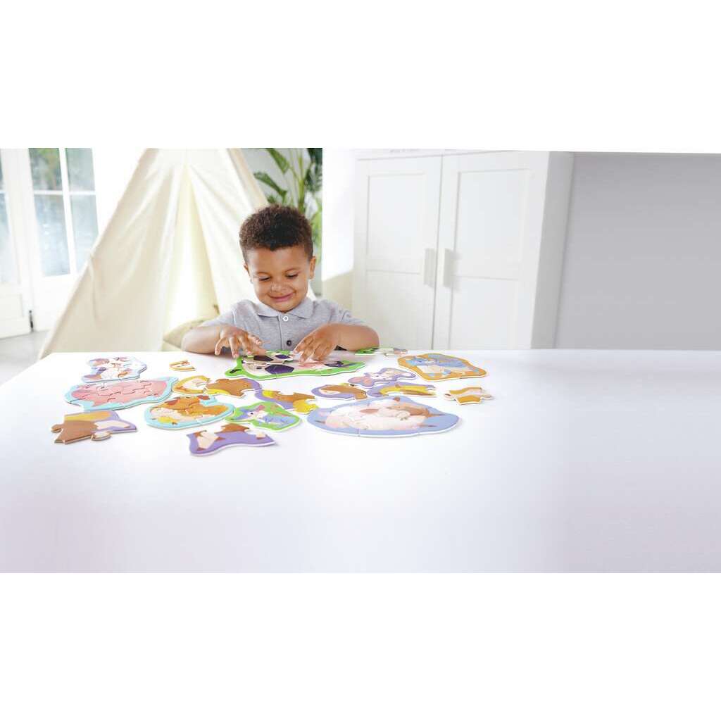 Niño montando puzzle de vaca del set Amigos de la Granja de Hape.