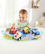 Bebé empujando uno de los coches de peluche Hape mientras juega.
