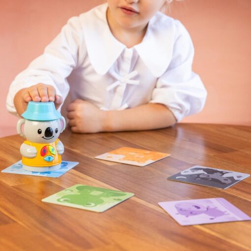 Niño jugando con el personaje electrónico Coco y las tarjetas de animales.